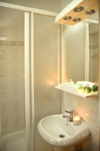 Un baño con lavabo, espejo y bañera. en Apartmani Boss, en Vrnjačka Banja