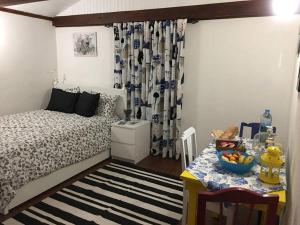 a bedroom with a bed and a table with a bowl of fruit at Adega guest house in Horta