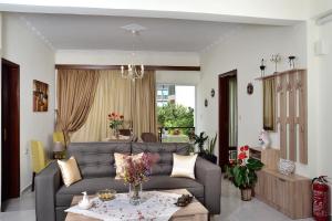 ein Wohnzimmer mit einem Sofa und einem Tisch in der Unterkunft Aristea's Apartment in Chania