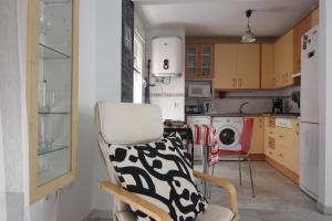 Apartamento VELADOR del Sur by Cadiz4Rentals في كاديز: مطبخ مع كرسي وغسالة ملابس