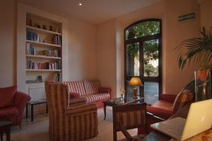 Elle comprend un salon doté d'un mobilier rouge et d'une fenêtre. dans l'établissement Hotel Arnolfo & Aqua Laetitia Spa & Beauty, à Montecatini Terme
