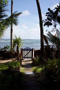 a gate leading to a beach with the ocean at Pousada Vila Sereia in Ilha de Boipeba