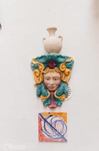 マツァーラ・デル・ヴァッロにあるLe Stanze Del Vicoloの壺を壁に描いた女性の胸像