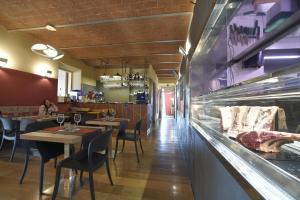 a restaurant with tables and chairs and a counter at Locanda La Bottega del Parco in Pisa