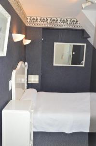 a bedroom with a white bed and a mirror at Hotel Victor Hugo in Amiens