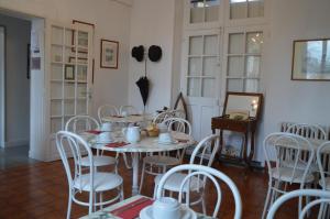 a dining room with white chairs and a table at Hotel Victor Hugo in Amiens