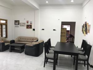 a living room with a couch and a table and chairs at Birunthavanam in Vavuniya