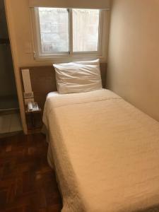 a bed in a small room with a window at Colatina Plaza Hotel in Collatina