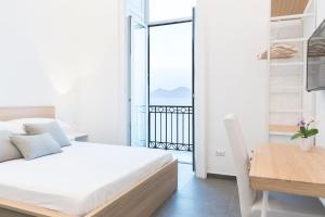 1 dormitorio con cama, mesa y balcón en Lux, en Nápoles