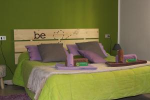 sypialnia z łóżkiem i zieloną ścianą w obiekcie Sa Babbaiola w Cagliari