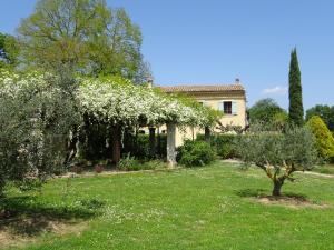 un giardino con una casa e un albero con fiori bianchi di GOLF CLUB D'UZES a Uzès