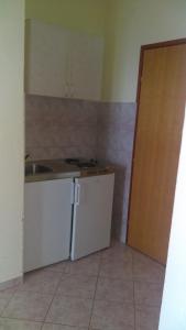 a kitchen with a sink and a white refrigerator at Guesthouse BILI in Karlobag