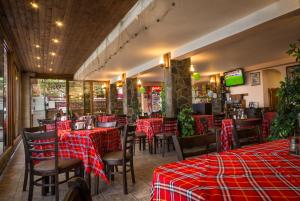 a restaurant with red checked tables and chairs at Guest House Karamihalevi in Sozopol