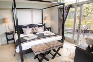 una camera con letto a baldacchino e balcone di The Cow Shed - with hot tub a Kirkby Lonsdale