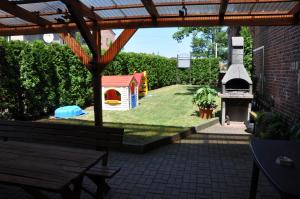 a backyard with a play yard with a play house at Budziar - kwatery nad morzem in Darłowo