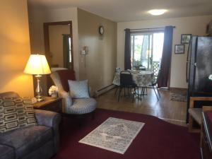 a living room with a couch and chairs and a table at Milford Motel On the River in Milford