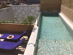 馬拉喀什的住宿－里亞德豪杜賓館，一个带两把草坪椅的游泳池