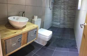 ein Bad mit einem Waschbecken und einem WC in der Unterkunft The Sail Loft - Hayling Island in South Hayling