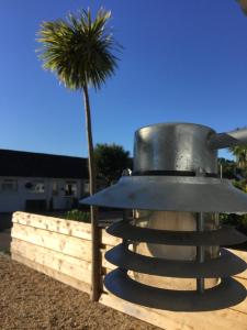 a bird bath with a palm tree in the background at The Sail Loft - Hayling Island in South Hayling