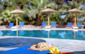 um chapéu sentado numa mesa ao lado de uma piscina em Viva Mare Hotel & Spa em Mithimna