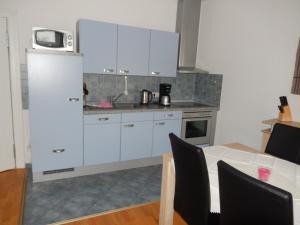 cocina con armarios blancos y mesa con microondas en Villa Bellevue Ferienwohnung 6, en Ahlbeck