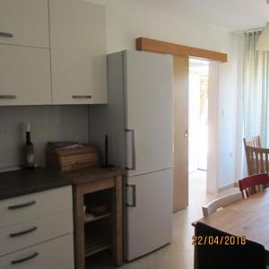 a kitchen with a white refrigerator and a table at Holiday House Sara in Opatija