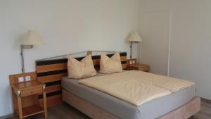 um quarto com uma cama com duas mesas de cabeceira e dois candeeiros em Herberge 39 em Meissen