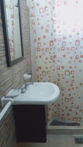 a bathroom with a sink and a shower curtain at Hotel Nuevo Fatica in Villa Carlos Paz