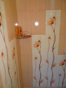 a bathroom with a shower with flowers painted on the wall at Orange Flower Apartments in Sofia