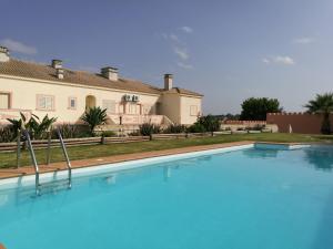 a large blue swimming pool in front of a house at Apartamento Patel in Poço Partido