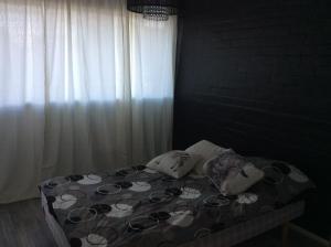 uma cama com duas almofadas e uma janela num quarto em Heleenkatu 3 a 1 oma sauna autokatos omassa pihassa em Seinäjoki
