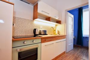 a kitchen with white cabinets and a stove top oven at City Central Apartments Wrocław in Wrocław