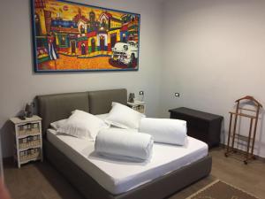 een bed in een kamer met een schilderij aan de muur bij La Casa Della Zia in Bordighera