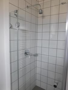bagno con doccia e piastrelle bianche di apartment Neðra-Vatnshorn a Hvammstangi