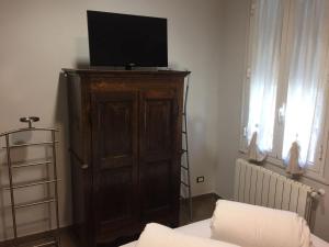 een woonkamer met een televisie op een houten kast bij La Casa Della Zia in Bordighera