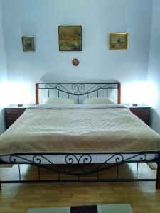 a bed in a bedroom with two pictures on the wall at Mama Brasov in Braşov