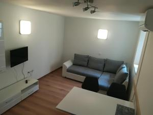 sala de estar con sofá y TV en Top Line Apartments, en Piran