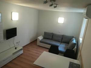 a living room with a couch and a tv at Top Line Apartments in Piran