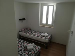 two beds in a small room with a window at Top Line Apartments in Piran