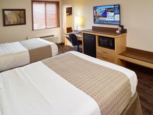 a hotel room with two beds and a flat screen tv at LivINN Hotel Minneapolis South / Burnsville in Burnsville