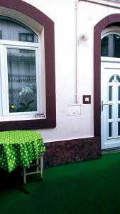 una mesa verde frente a un edificio con ventana en Mama Brasov en Braşov