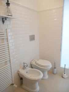 a white bathroom with a toilet and a sink at Una finestra sul lago..Appartamento Verbania in Verbania