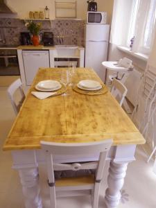 a kitchen with a wooden table with plates and glasses on it at Una finestra sul lago..Appartamento Verbania in Verbania