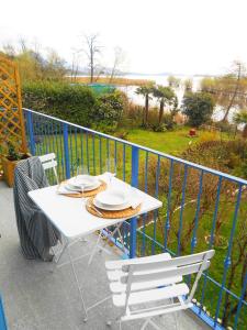a white table and chairs on a balcony at Una finestra sul lago..Appartamento Verbania in Verbania