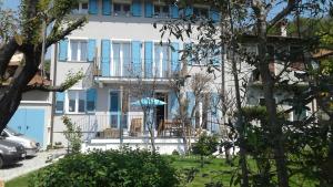 a large white building with blue shutters on it at Una finestra sul lago..Appartamento Verbania in Verbania