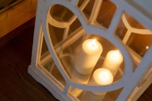 een paar kaarsen in een hartvormige spiegel bij Hotel Chalet Giasenei in Sagron Mis