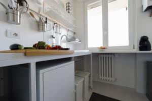una cucina con banconi bianchi e piano di lavoro di Little House With Lake View ad Arona