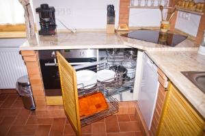 a kitchen with an oven with dishes in it at Harmatcsepp-Vendégház in Kercaszomor