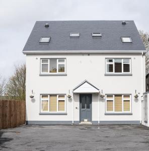 a white house with a black roof at Waterlane Apartments in Galway