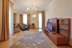 a living room with a television and a couch at Serviced Apartment on Rustaveli Avenue in Tbilisi City